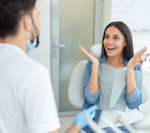 Young woman smiling at a dental professional and happy about the results of her smile