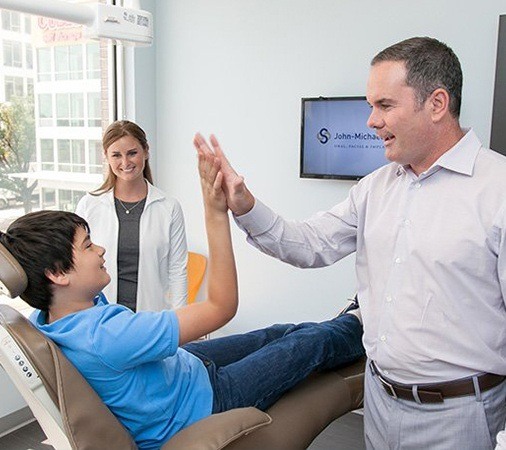 Dentist giving teen patient a high five