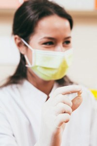 A dentist showing her patient an extracted tooth