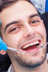 A young male having his teeth checked and learning about the benefits of dental implants in Prosper