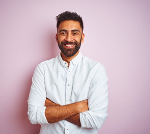 a smiling man with his arms crossed