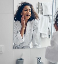 woman looking in a bathroom mirror