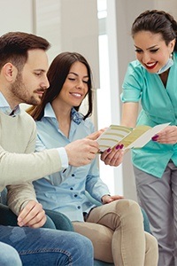 Team member discussing financing with two dental patients