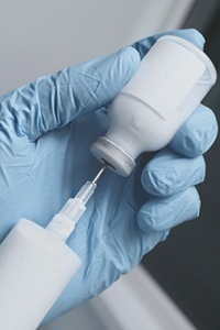 A syringe being used to pull medication from a bottle