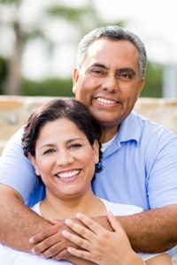 An older couple hugging outside.