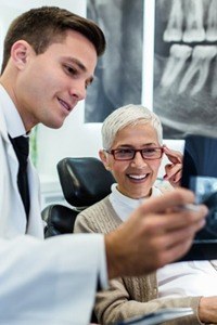 A dentist showing a patient an X-ray.