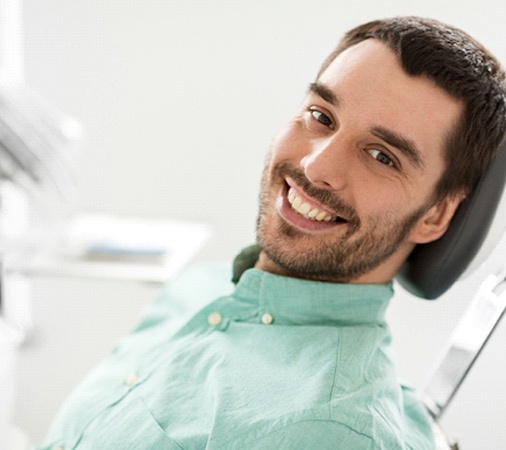 A young man with a beard sitting back in a dentist’s chair preparing to undergo nitrous oxide sedation