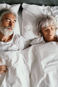 older couple sleeping in bed 