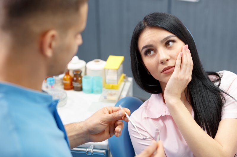 A woman holding her jaw due to wisdom tooth pain