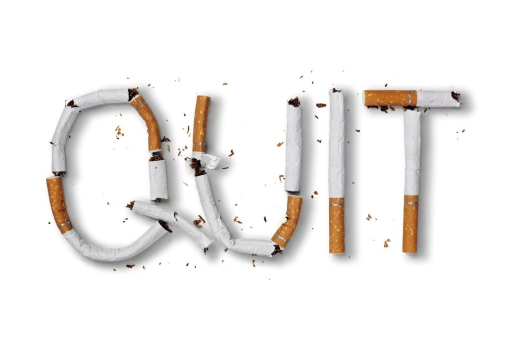 The word “quit” spelled out in cigarettes.